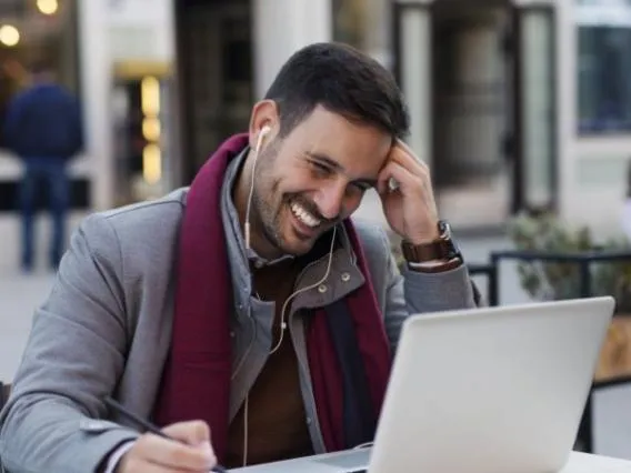 Man sitting outside having a video call on this laptop